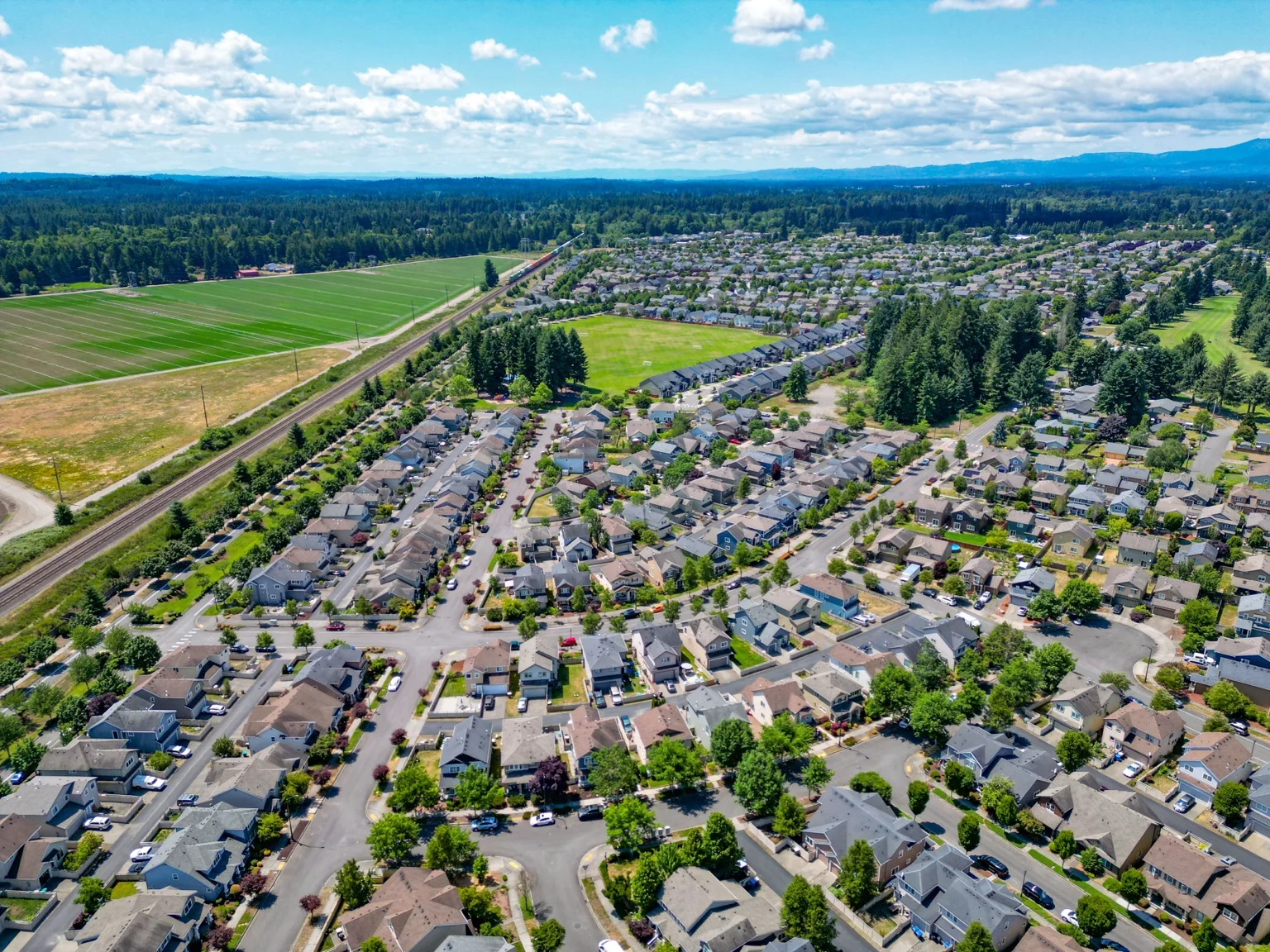 Aerial view of Lacey residential neighborhoods beside open farmland and green space