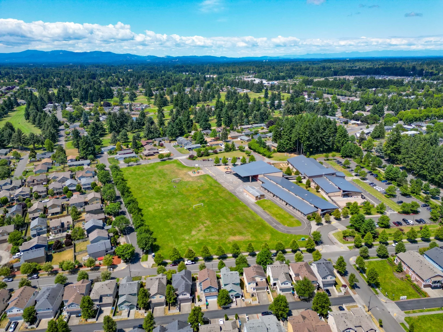 Aerial view of a Lacey neighborhood with school buildings, playfields, and nearby homes